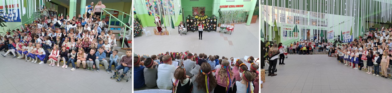 Atrium szkoły, siedzące dzieci śpiewające piosenki